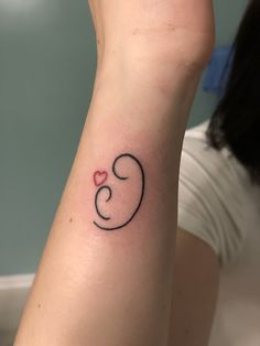 a woman's arm with a tattoo on it that has the letter e and heart