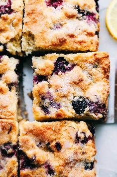 blueberry crumb bars cut into squares on a cutting board next to lemon wedges