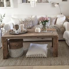 a living room filled with furniture and flowers on top of a table in front of a couch