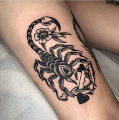 a black and white tattoo on the leg of a woman's legs, with an image of a scorpion