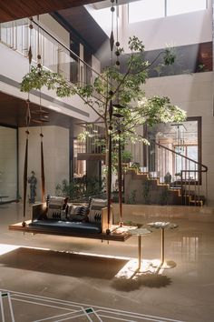 a living room filled with lots of furniture next to a tall tree in the middle