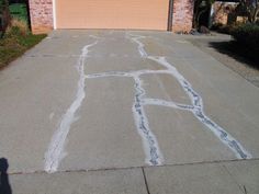 the driveway has been painted with chalk and is next to a garage