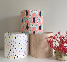 three rolls of toilet paper sitting on top of a table next to a potted plant