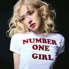 a woman with blonde hair wearing a white t - shirt that says number one girl