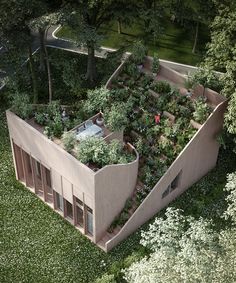 an aerial view of a building surrounded by trees and bushes with people walking around it