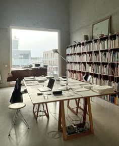 a long table sitting in front of a book shelf filled with books