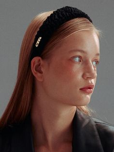 a young woman wearing a black headband and looking off into the distance