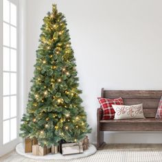 a decorated christmas tree in the corner of a room next to a bench with presents on it