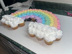 there are cupcakes that have been made to look like rainbows on the table