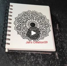 a spiral notebook with the title jalis creations on it, sitting on a table