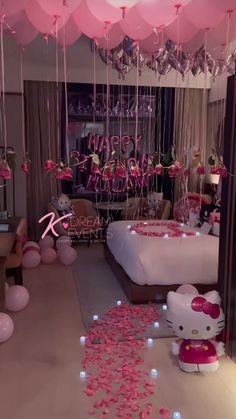 a hello kitty themed bedroom with balloons and streamers on the ceiling, pink bedding