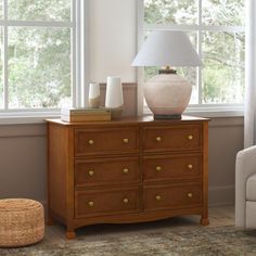 a white lamp sitting on top of a wooden dresser