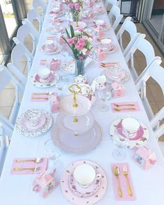 the table is set with pink and white china