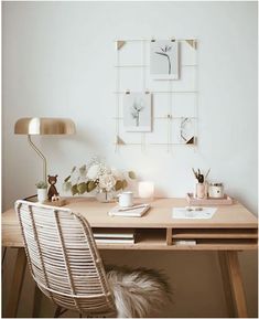 a desk with a chair, lamp and pictures on the wall in front of it