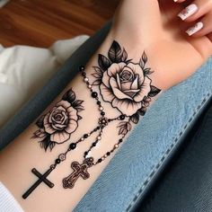 a woman with a cross and roses tattoo on her arm