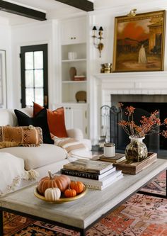 a living room filled with furniture and a fire place in front of a white couch