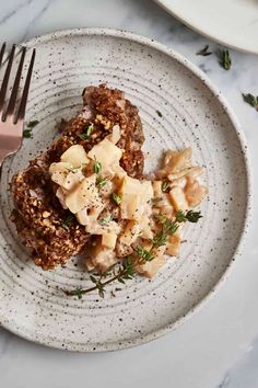 a white plate topped with food next to a fork