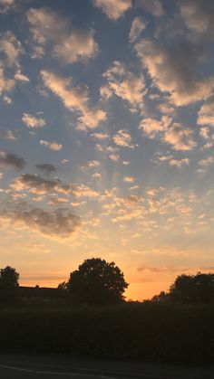 the sun is setting behind some trees