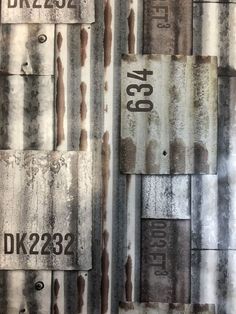 an old metal wall with rusted paint and numbers on it's sides, as well as the word dk232