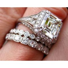 a woman's engagement ring and wedding band with an emerald cut diamond in the center