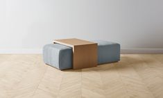 a blue and brown bench sitting on top of a hard wood floor next to a white wall