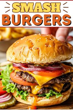 a cheeseburger with tomatoes, onions and lettuce on it is being held up in front of the camera