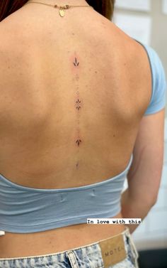 the back of a woman's neck with arrows on it