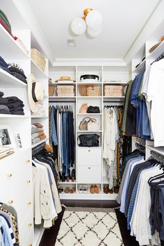 an organized closet with clothes, hats and other items on shelves in white painted walls