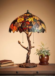 a lamp that is sitting on top of a table next to a potted plant