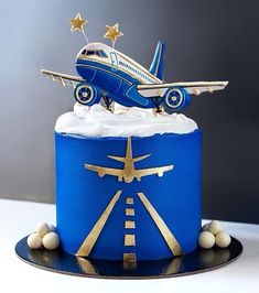 a blue and white cake with an airplane on top