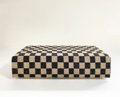 a black and white checkered ottoman sitting on top of a floor