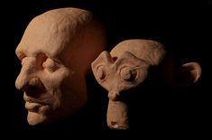 two clay heads are shown with one being an adult and the other is a child