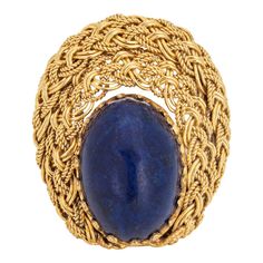 This is part of Chairish’s Fine Jewelry assortment.  Stylish lapis lazuli cocktail ring crafted in 18 karat yellow gold (circa 1960s to 1970s).   Cabochon cut lapis lazuli measures 13mm x 10mm. The lapis is in very good condition and free of cracks or chips.   Rich cobalt blue Lapis lazuli is perched on a beautifully detailed woven mount, in an almost halo like design that is so visually appealing. The butteryness of the 18k gold setting and contrasting rich cobalt blue lapis makes a bold statement on the hand. The medium rise ring (12mm - 0.47inches) sits comfortably on the finger.   The ring is in very good condition and was lightly cleaned and polished.   Particulars:  Weight: 8.6 grams  Stones:  Cabochon cut lapis lazuli measures 13mm x 10mm. The lapis is in very good condition and fre Masonic Jewelry, Russian Jewelry, Yellow Gold Cocktail Ring, Green Cocktail, Vintage Cocktail Ring, Lapis Lazuli Ring, Gold Cocktail Ring, Blue Lapis Lazuli, Gold Cocktail