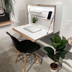 an open laptop computer sitting on top of a desk next to a potted plant