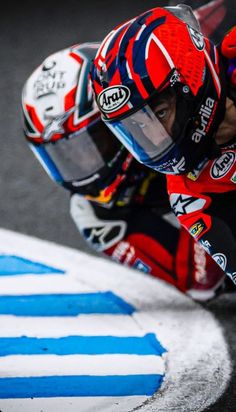 a man riding on the back of a motorcycle down a race track