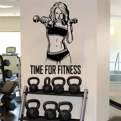 a gym wall decal with a woman holding dumbbells and the words time for fitness