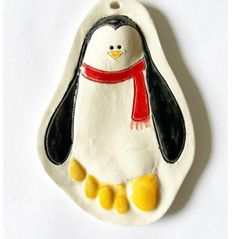 a ceramic ornament with a penguin wearing a scarf