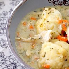 a bowl filled with chicken and dumplings on top of a doily covered table