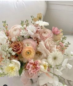 a bouquet of flowers sitting on top of a white couch