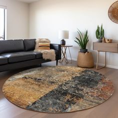 a living room with black leather couches and an area rug