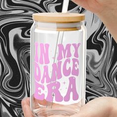 a person holding a glass jar with the words in my dance era on it