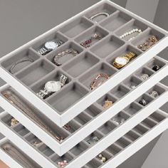 three white drawers filled with jewelry on top of each other