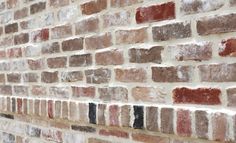 an old brick wall with red and brown bricks