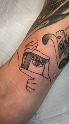 a man's arm with an eye looking through a magnifying glass tattoo