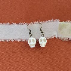 At just an inch long, these Howlite skull drop earrings are perfect as a small Halloween accent, but they can also be worn year round! They are hung on hypoallergenic, nickel-free ear wire and come with rubber backs for additional support. The earrings are lovingly beaded by a working mom in Phoenix, Arizona. Thank you for viewing and supporting small businesses! Bone Colored Earrings With Ear Wire For Gift, Adjustable Skull-shaped Earrings With Ear Wire, Adjustable Skull Shaped Earrings With Ear Wire, Horror Earrings, Earrings Halloween, Working Mom, Skull Earrings, Halloween Earrings, Phoenix Arizona