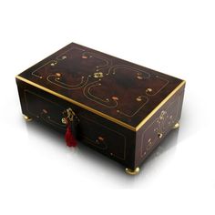 a wooden box with gold trimmings and red tasseling on the lid