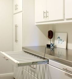 a kitchen with white cabinets and silver counter tops on top of it's drawers