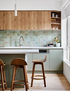 two wooden stools in front of a kitchen counter