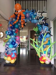 an arch made out of balloons with fish and sea creatures on it in a hallway