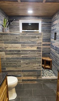 a small bathroom with stone walls and tile flooring